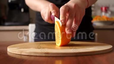 女人`手在厨房里切鲜橙色。